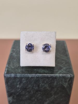 a pair of tanzanite earrings on a marble block