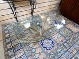 a glass table with a glass top sitting on a rug