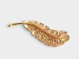 leaf shaped brooch with a gold leaf on a white background