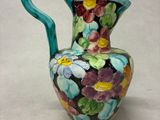 un vase coloré orné de fleurs, posé sur une table