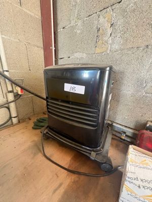 a black air conditioner sitting on the floor next to a box