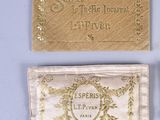 two gold business cards and a gold purse on a blue surface