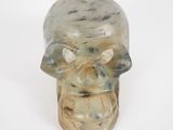 un crâne en verre avec un visage sur un fond blanc