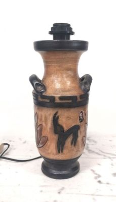 un vase marron orné d'un chat noir, posé sur une table