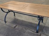 a wooden table with a metal base and a wooden top