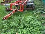 a tractor that is sitting in the grass with a plow
