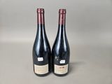 two bottles of red wine sitting next to each other on a table