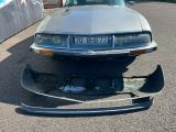 une photo d'une voiture endommagée, garée sur un parking