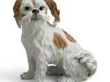 une figurine de chien assise sur une surface blanche