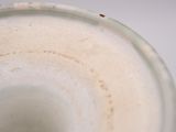 a close up of a white vase with a brown spot on it