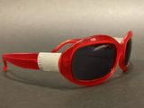 red and white sunglasses with black lenses on a gray surface
