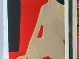 a picture of a woman sitting on a chair in front of a painting