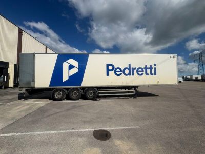 un semi-remorque garé devant un immeuble