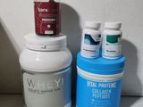 Des bouteilles de lactosérum, de collagène et de peptides sont posées sur un plan de travail