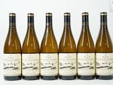 six bouteilles de vin sont alignées sur une table