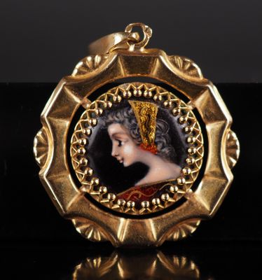 un pendentif plaqué or représentant le portrait d'une femme coiffée d'une couronne