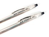 two pens with air france written on them sitting on a white surface
