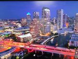 the city skyline is lit up at night with the lights on