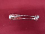une vieille cuillère en argent posée sur une nappe rouge, avec un manche en argent