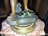 une statue représentant une femme tenant un poisson sur une table