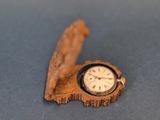 une petite horloge en bois en forme de feuille
