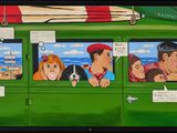 tableau représentant un groupe de personnes à bord d'un bus vert sur le toit duquel est posée une planche de surf