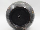 a black vase that has a design on it