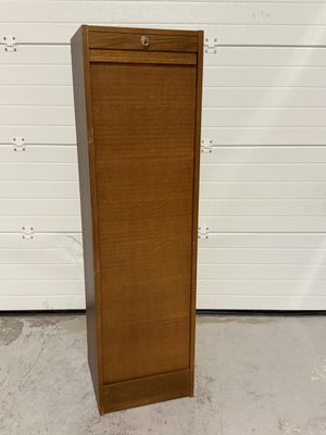 une photo montrant une grande armoire en bois devant une porte de garage