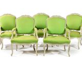 six green upholstered chairs are lined up against a white background