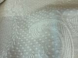 a close up of a bed with a white comforter on it