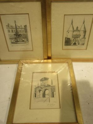 two framed pictures of a building and a church in a gold frame