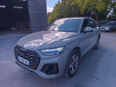 un SUV Audi gris garé devant un garage