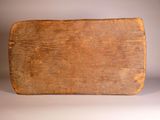 an old wooden cutting board on a white surface