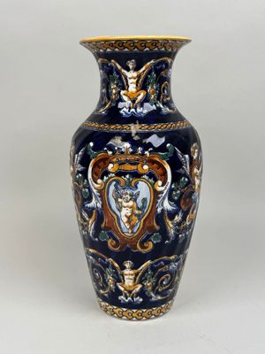 a blue and gold vase sitting on a white surface