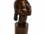sculpture of a woman ' s head on a wooden base