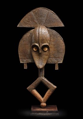une sculpture en bois représentant une tête d'homme, posée sur un socle