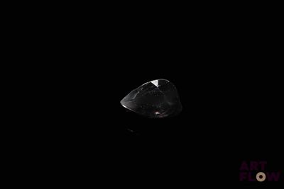 a close up of a diamond in the dark with a black background