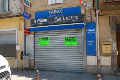 une voiture garée devant un immeuble sur laquelle sont apposées des affiches