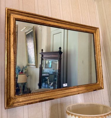 a mirror hanging on the wall next to a vase