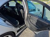 a silver car with its door open on the side of the road