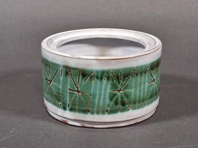 un pot vert et blanc contenant un cactus