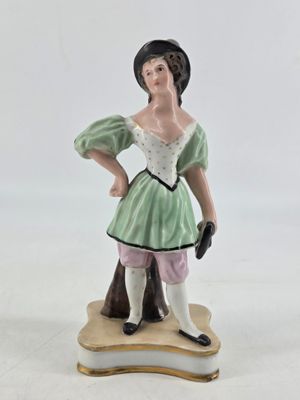 a figurine of a woman in a green dress and hat