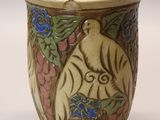 a vase with a bird and flowers on it