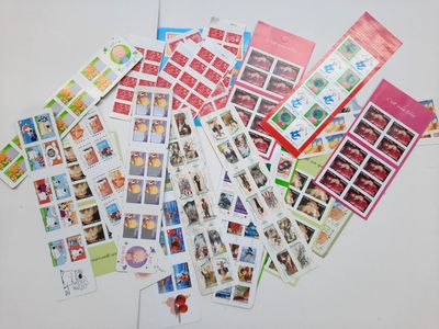 une pile de timbres posée sur une table, avec une épingle rouge