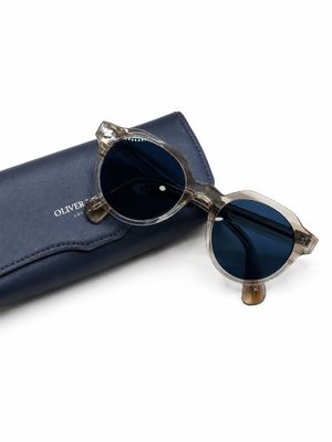 des lunettes de soleil dans un étui bleu sur fond blanc