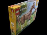 une boîte de Lego Creator représentant des chevaux sur fond noir