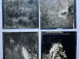four black and white photographs of a city with smoke coming out of it