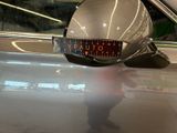 a reflection of a person in the mirror of a car