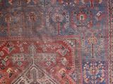 an antique persian rug with a red and blue design
