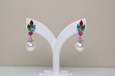 pair of multicolored crystal and pearl earrings on a white stand